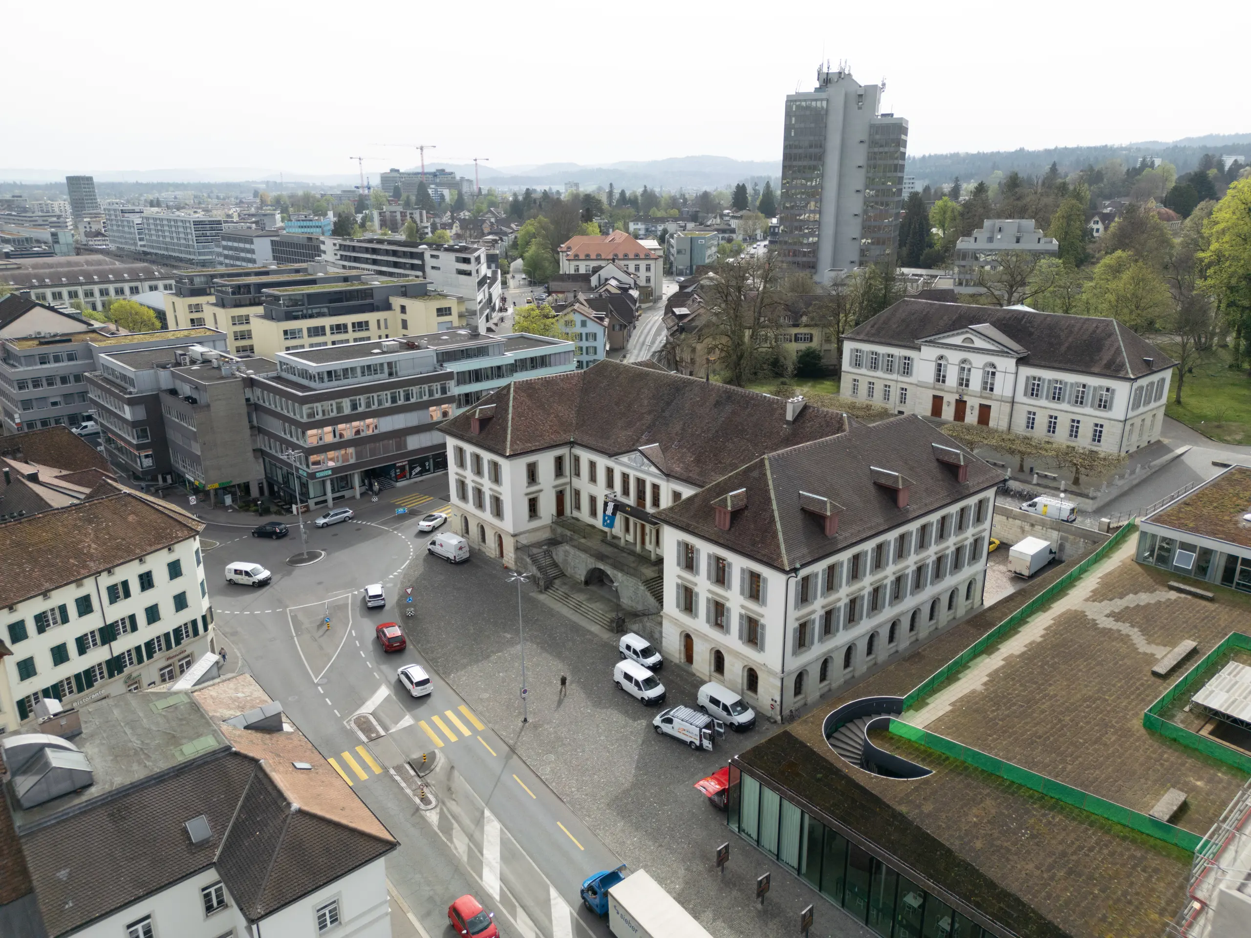 Luftaufnahme von Aargau im Jahr 2025 mit klassischer Stadtarchitektur, wenig Grünflächen und starkem Verkehrsaufkommen.