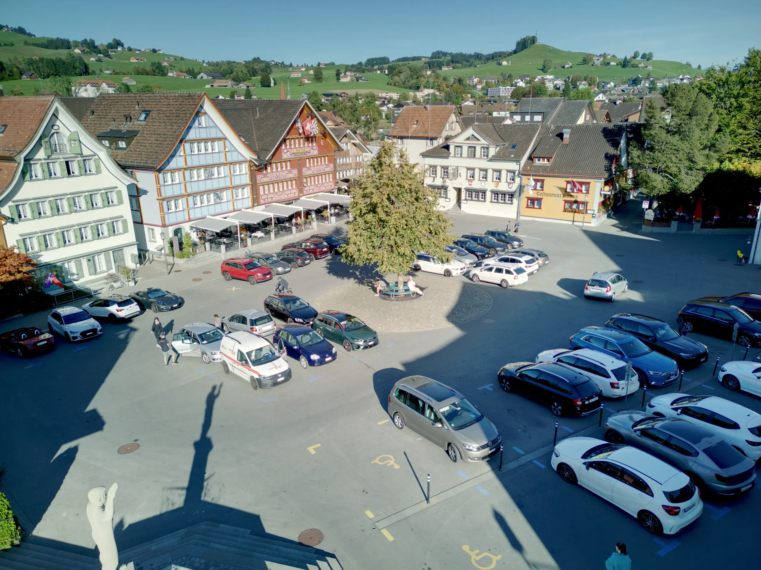 Luftaufnahme des Marktplatzes in Appenzell, geprägt von parkenden Autos und einer autodominierten Infrastruktur.
