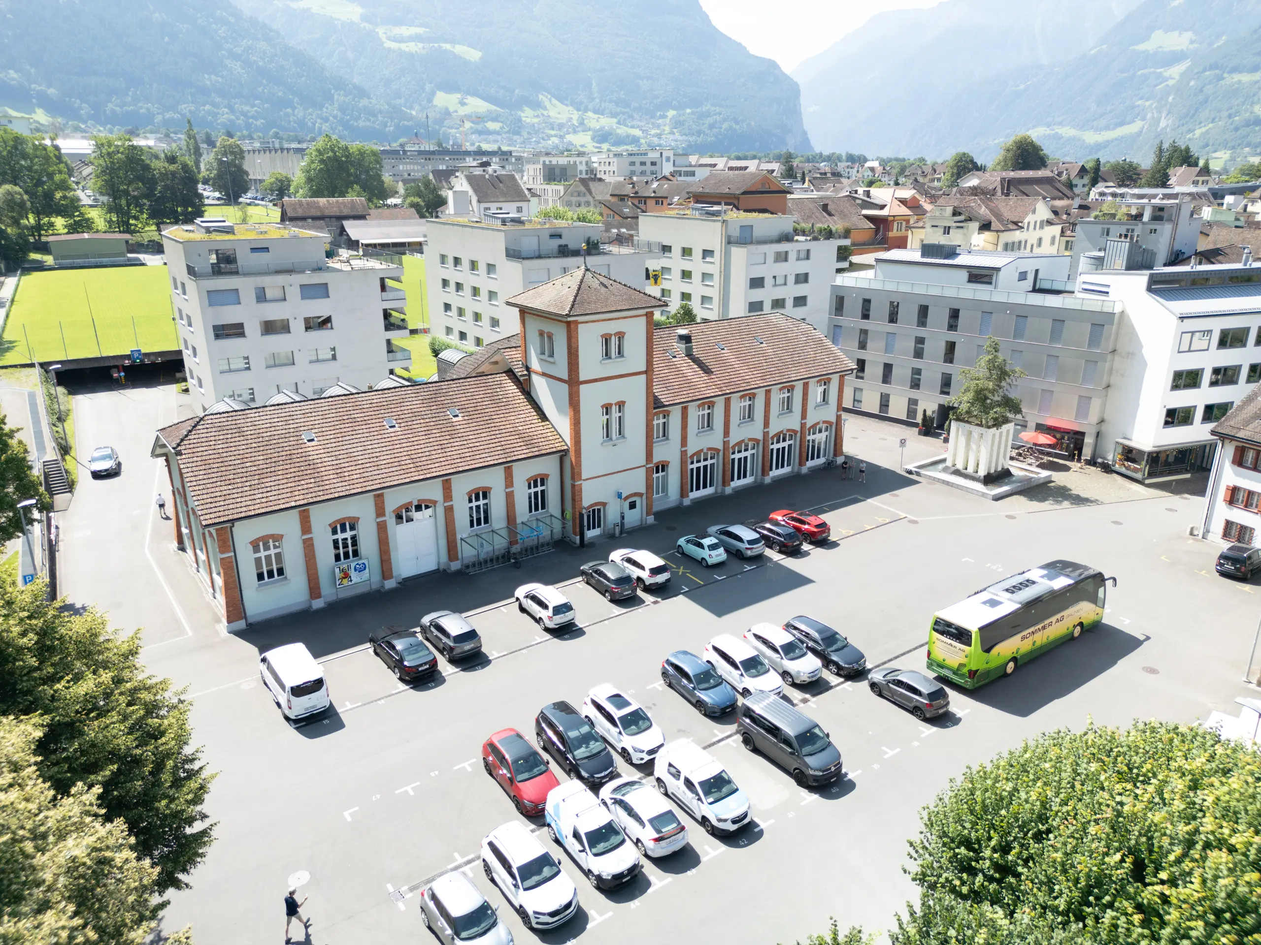 Altstadt in Uri 2025 – großer Parkplatz mit wenig Begrünung, umgeben von traditionellen Gebäuden und moderner Architektur.